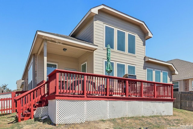 rear view of property featuring fence and a wooden deck