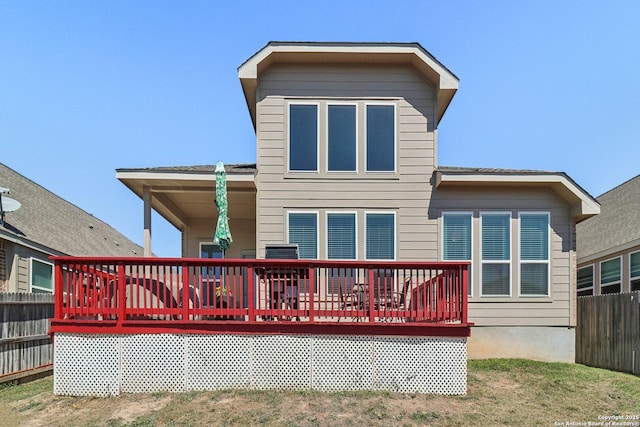 rear view of property featuring a yard, fence, and a wooden deck