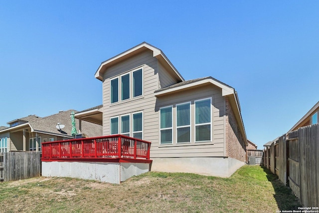 rear view of house featuring a fenced backyard, a deck, and a yard