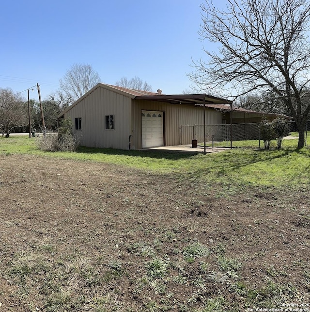 exterior space with an outbuilding, dirt driveway, and fence