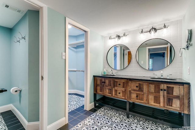 bathroom featuring a sink, visible vents, decorative backsplash, and tile patterned floors