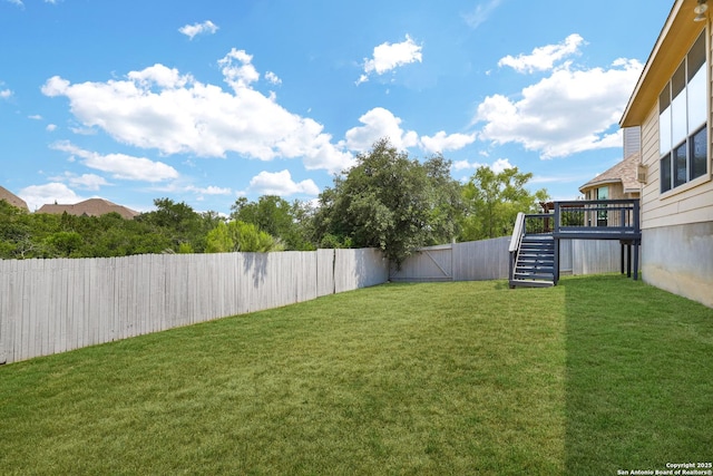 view of yard with stairs and a fenced backyard