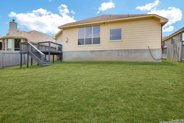 back of property featuring a yard, a wooden deck, stairs, and fence