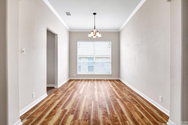 unfurnished dining area with baseboards, visible vents, hardwood / wood-style flooring, crown molding, and a chandelier