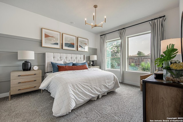 bedroom featuring a chandelier, baseboards, and carpet floors