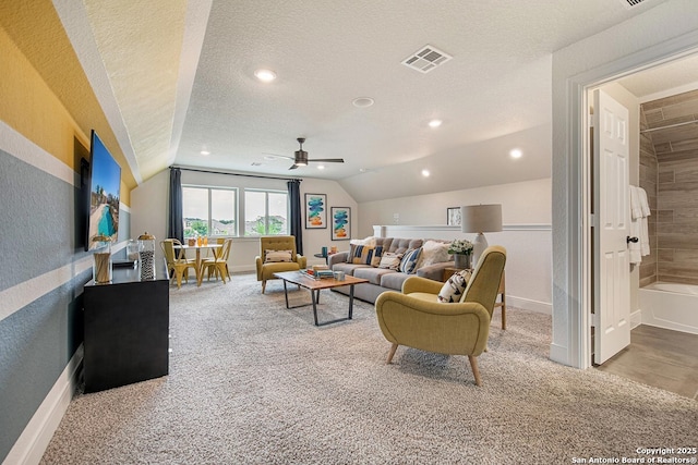 carpeted living room featuring visible vents, vaulted ceiling, recessed lighting, a textured wall, and a textured ceiling