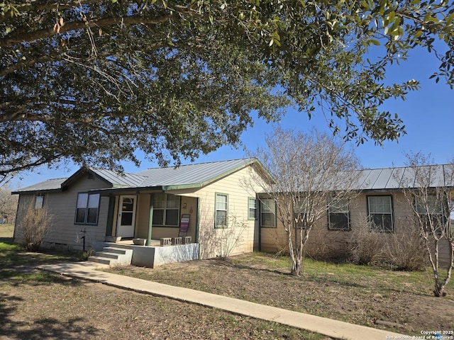 ranch-style house with covered porch and metal roof