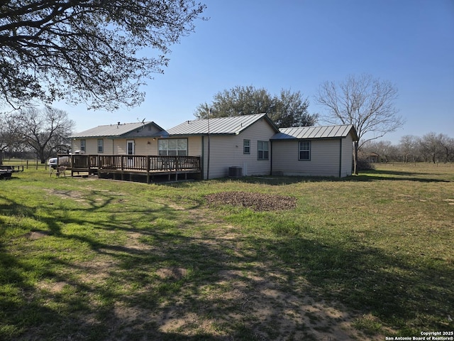 back of house with a yard, metal roof, a deck, and a standing seam roof