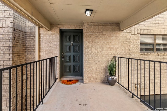 doorway to property with brick siding