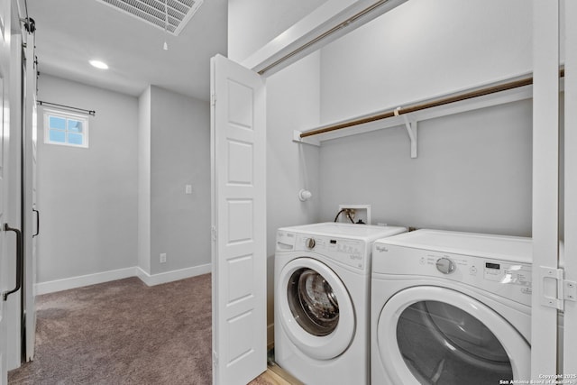 washroom featuring visible vents, washing machine and dryer, baseboards, light colored carpet, and laundry area