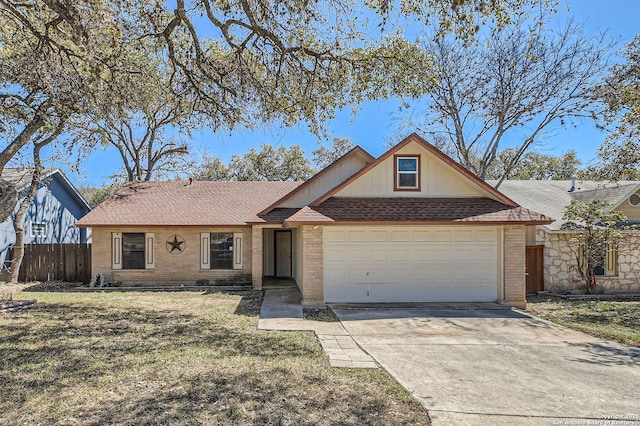 view of front facade with driveway, brick siding, an attached garage, and fence