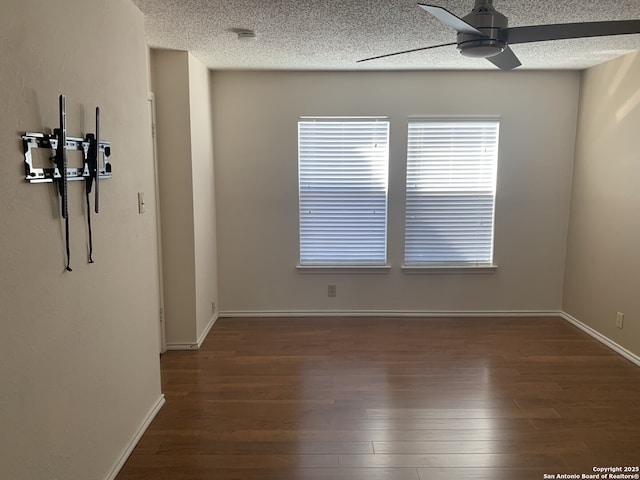 empty room featuring ceiling fan, baseboards, a textured ceiling, and wood finished floors