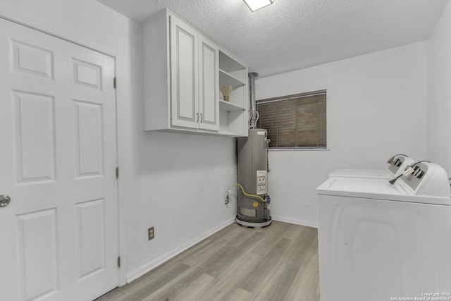 clothes washing area with baseboards, cabinet space, water heater, light wood-style floors, and washing machine and dryer