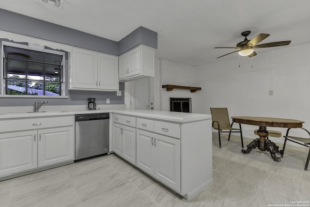 kitchen with a sink, a peninsula, light countertops, and stainless steel dishwasher