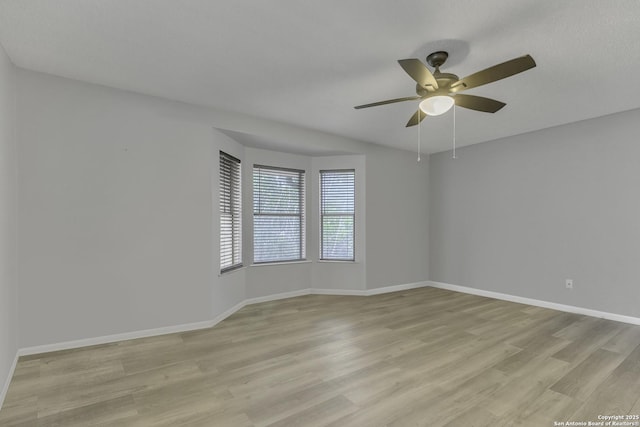 unfurnished room with light wood finished floors, ceiling fan, and baseboards