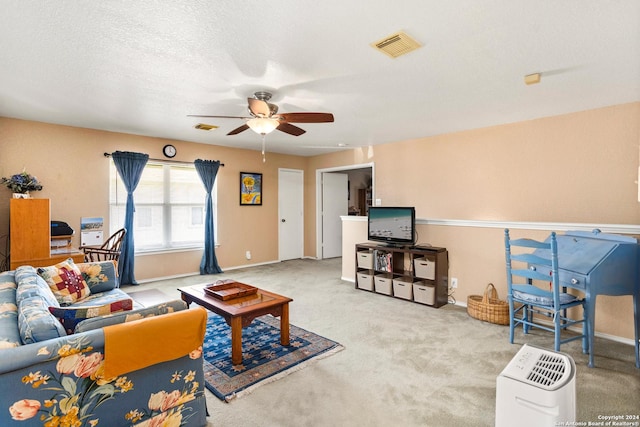 living area with ceiling fan, carpet flooring, visible vents, and a textured ceiling