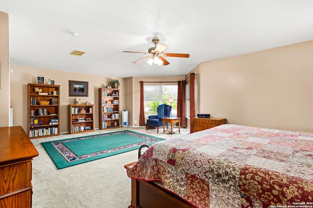 carpeted bedroom with a textured ceiling and a ceiling fan