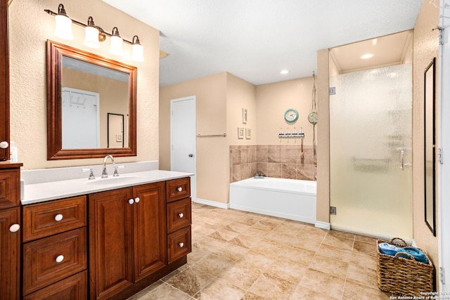 full bathroom with baseboards, a shower stall, vanity, and a garden tub