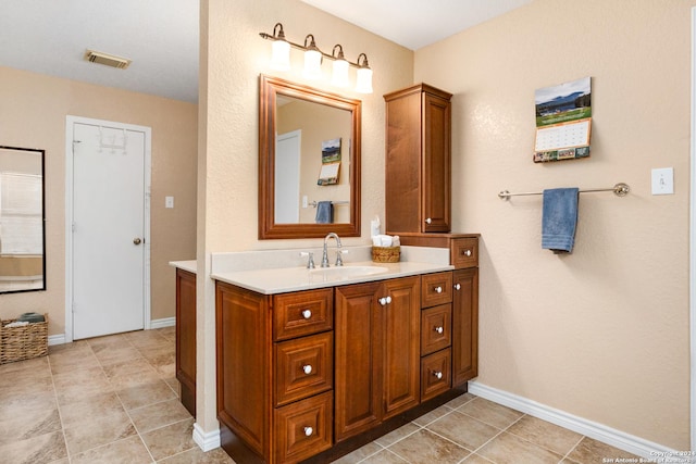 bathroom with tile patterned floors, visible vents, vanity, and baseboards