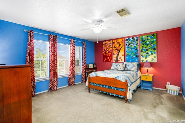 carpeted bedroom with a ceiling fan, baseboards, visible vents, and a textured ceiling