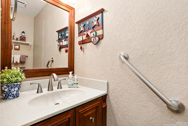 bathroom with vanity and a textured wall