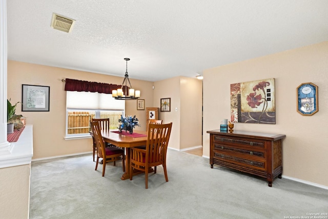 dining space with a notable chandelier, carpet, visible vents, and a textured ceiling