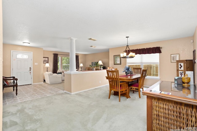 dining space featuring light carpet, visible vents, an inviting chandelier, and decorative columns