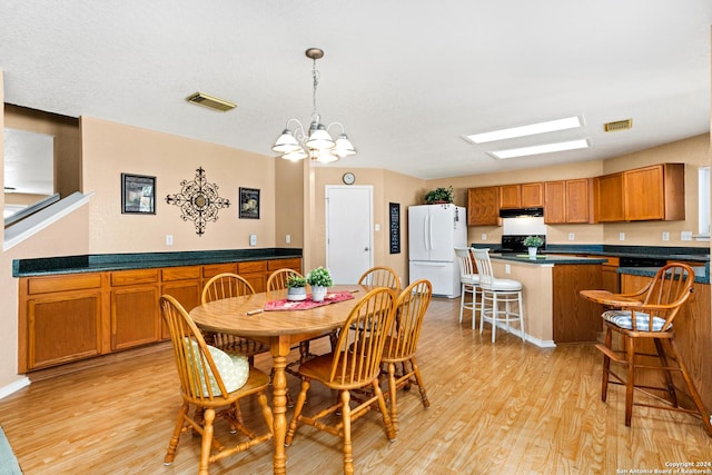 dining space with a notable chandelier, visible vents, and light wood finished floors