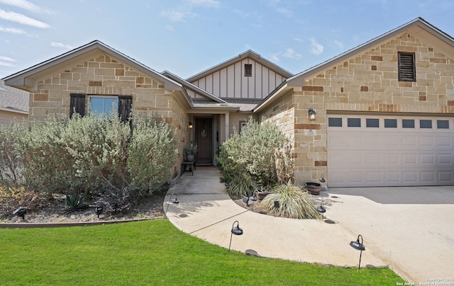 view of front facade with a front yard, an attached garage, concrete driveway, stone siding, and board and batten siding