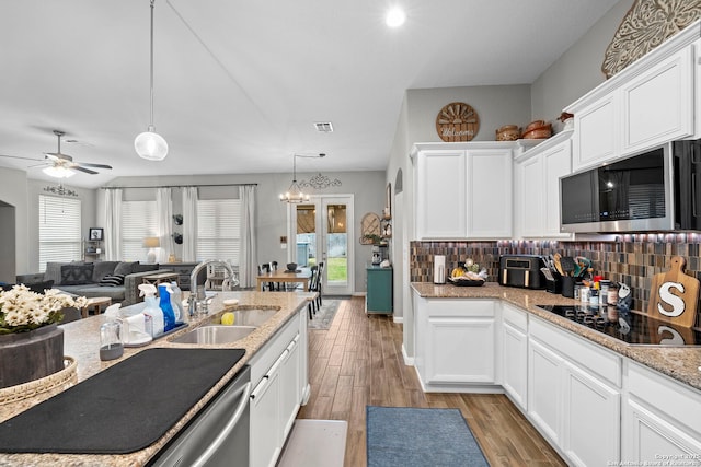 kitchen featuring light wood-type flooring, visible vents, a sink, tasteful backsplash, and stainless steel appliances