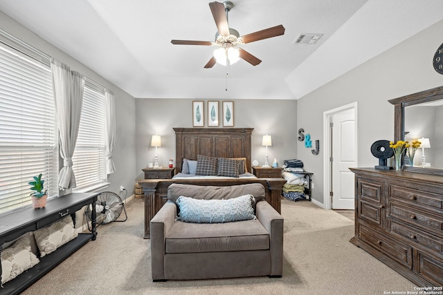 carpeted bedroom with a ceiling fan, a raised ceiling, visible vents, and baseboards