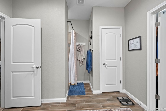 bathroom featuring baseboards and wood tiled floor