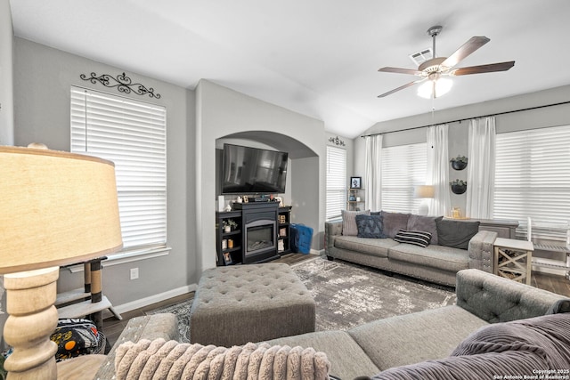 living room featuring visible vents, ceiling fan, baseboards, lofted ceiling, and wood finished floors