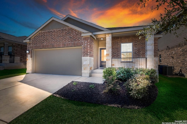 single story home with central air condition unit, stone siding, concrete driveway, a garage, and brick siding