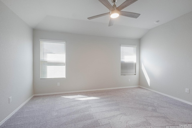 empty room featuring plenty of natural light, baseboards, ceiling fan, and vaulted ceiling