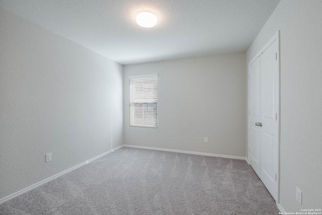 unfurnished bedroom featuring baseboards and carpet