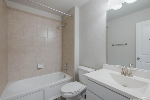 bathroom with toilet,  shower combination, vanity, and a textured wall