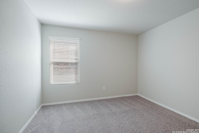 spare room featuring baseboards and carpet