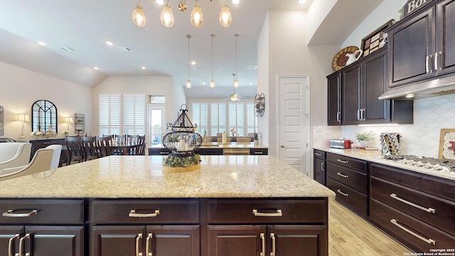 kitchen with visible vents, light wood finished floors, stainless steel gas cooktop, open floor plan, and backsplash