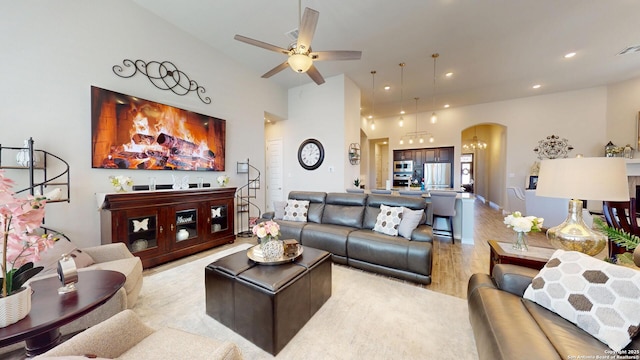 living area with light wood-style flooring, recessed lighting, arched walkways, baseboards, and ceiling fan