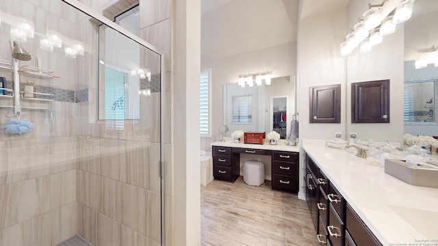 full bath featuring double vanity, wood finished floors, a stall shower, and a sink