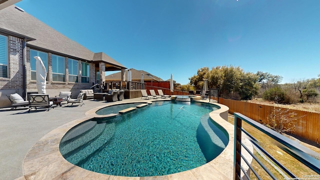 view of pool featuring a pool with connected hot tub, a fenced backyard, and a patio area