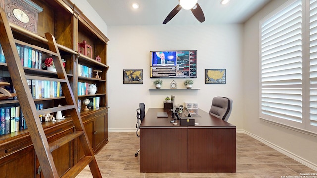 office space with a wealth of natural light, baseboards, a ceiling fan, and wood finish floors