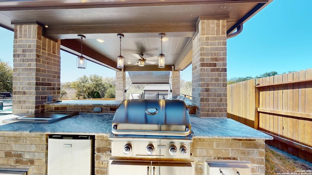 view of patio / terrace featuring a grill, exterior kitchen, a ceiling fan, and fence