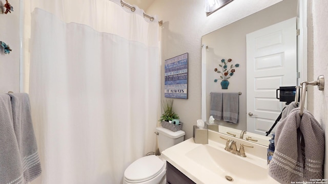 full bathroom featuring vanity, a shower with shower curtain, and toilet