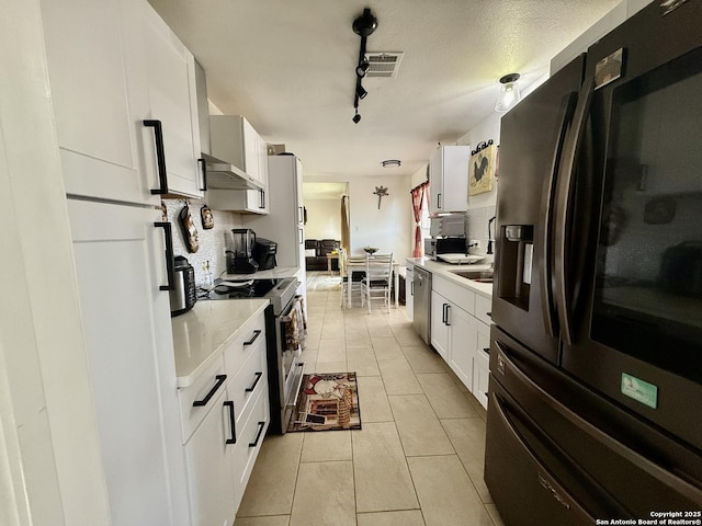 kitchen with decorative backsplash, light countertops, visible vents, and stainless steel appliances