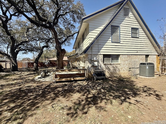 back of house featuring brick siding and cooling unit