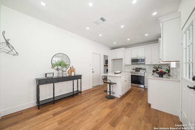 kitchen featuring white cabinetry, light countertops, light wood-type flooring, and appliances with stainless steel finishes