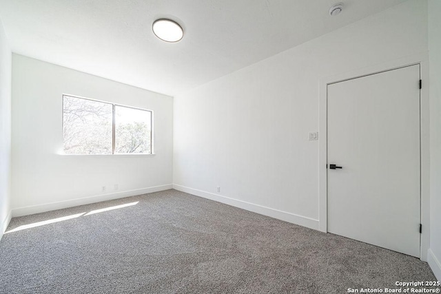 carpeted spare room with baseboards