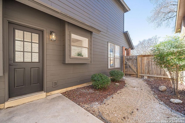 entrance to property with crawl space and fence